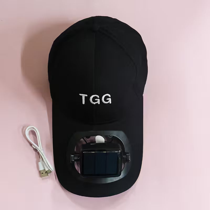 Black cap with 'TGG' branding and a USB cable on a pink background
