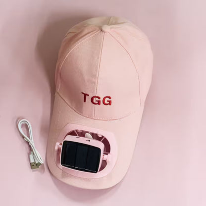 Pink cap with 'TGG' branding and electronic device on a pink background