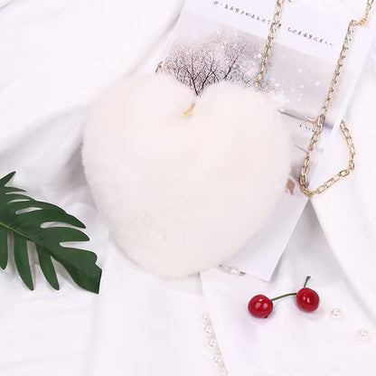 Necklace with cherry earrings on a white surface with a leaf and candle.