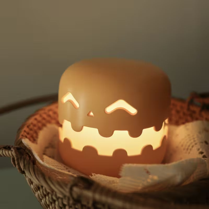 Ceramic pumpkin with a carved face glowing inside a woven basket on a dark background