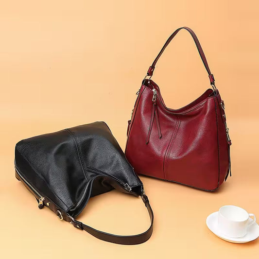 Black and red handbags on a beige background with a cup and saucer.