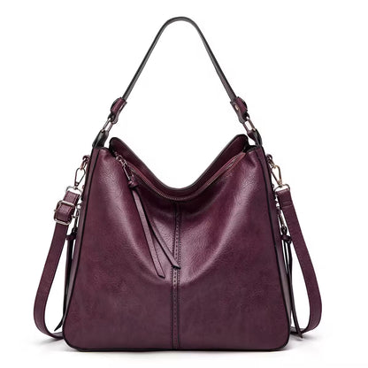 Purple handbag with a shoulder strap on a white background