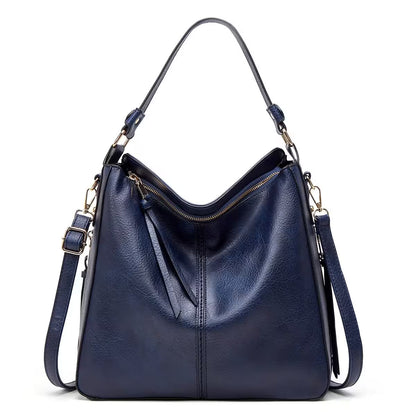 Blue leather handbag with gold zippers on a white background