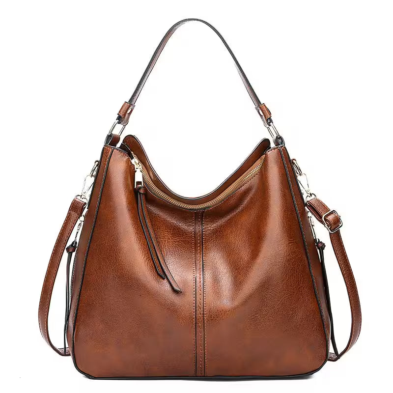Brown leather handbag with a shoulder strap on a white background
