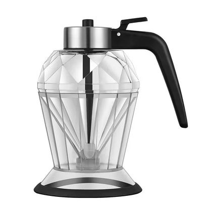 Clear blender pitcher with black handle and base on a white background