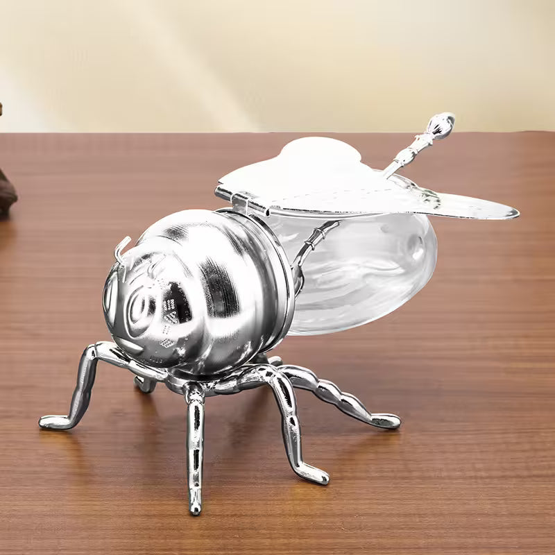 Metallic bee-shaped object on a wooden surface