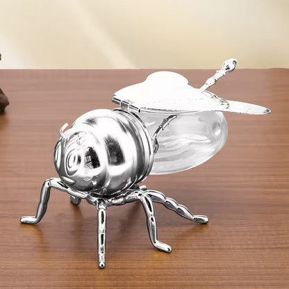 Metallic bee-shaped object on a wooden surface