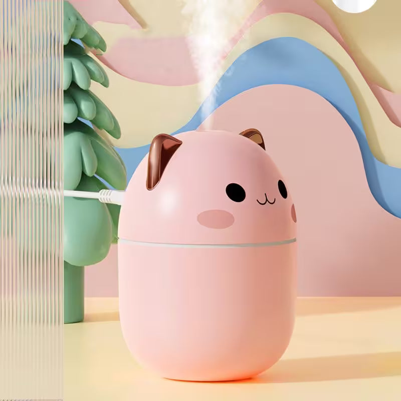 Pink cat-shaped humidifier with a cute face on a colorful abstract background