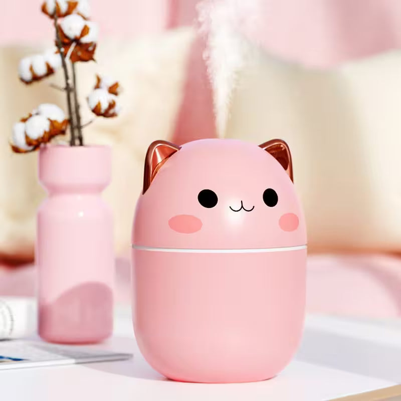Pink cat-shaped humidifier on a blurred background with cotton plants and soft lighting