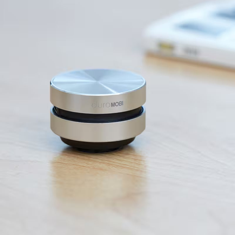 Small round device with 'CULMOMBI' branding on a wooden surface