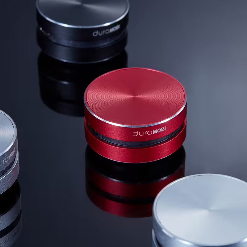Red metal grinder with 'duromobi' branding on a reflective surface