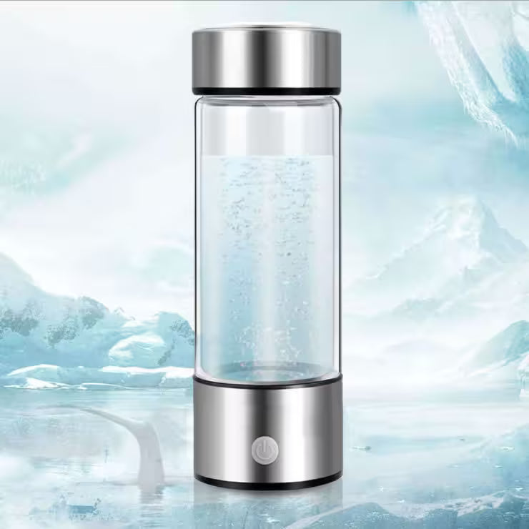 Glass water bottle with silver cap on a icy background