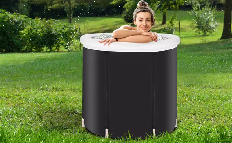 Woman relaxing in an inflatable hot tub outdoors on a grassy area