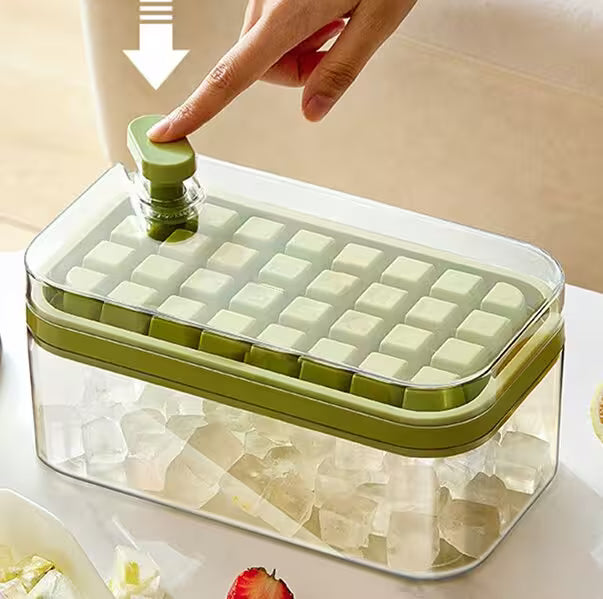 Green ice cube tray with a hand pressing down on it, set against a neutral background.