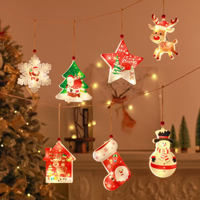 Set of Christmas-themed light-up decorations hanging against a warm, festive background.