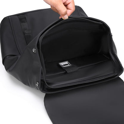 Black backpack with a hand opening it on a white background