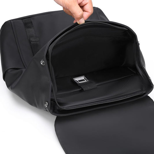 Black backpack with a hand opening it on a white background