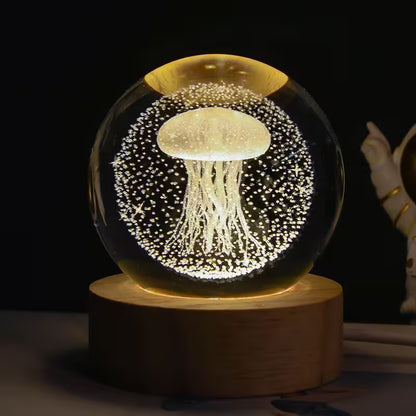 Glowing jellyfish inside a crystal ball on a wooden base against a dark background