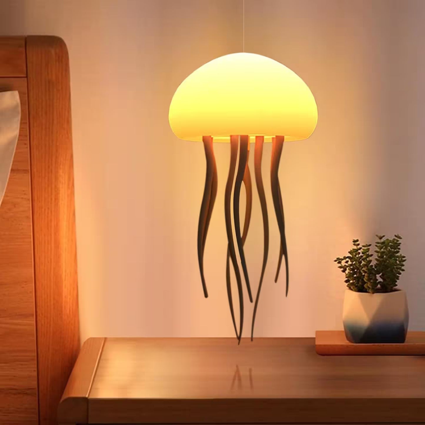 Jellyfish-shaped lamp on a wooden surface with a plant in the background