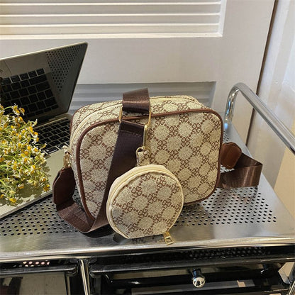 Patterned handbag and small pouch on a metallic surface with a laptop in the background.
