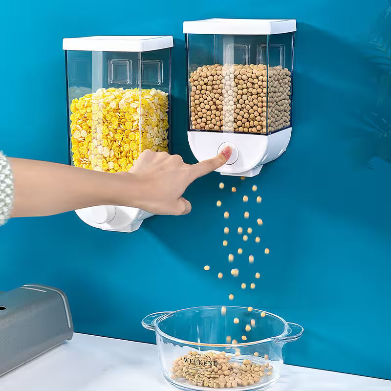Wall-mounted popcorn and kernel dispenser with a hand pressing a button, showing kernels falling into a bowl.