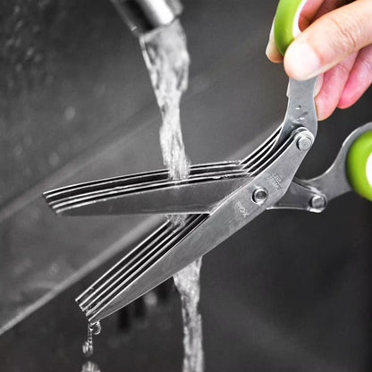 Scissors being rinsed under running water with a blurred background