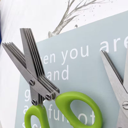Green-handled scissors cutting a piece of paper with text in the background