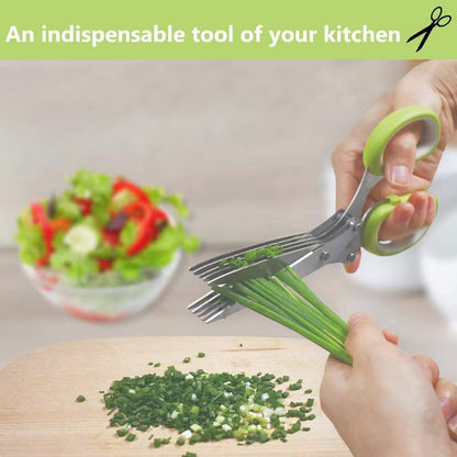 Scissors being used to chop green onions on a cutting board with a salad in the background.