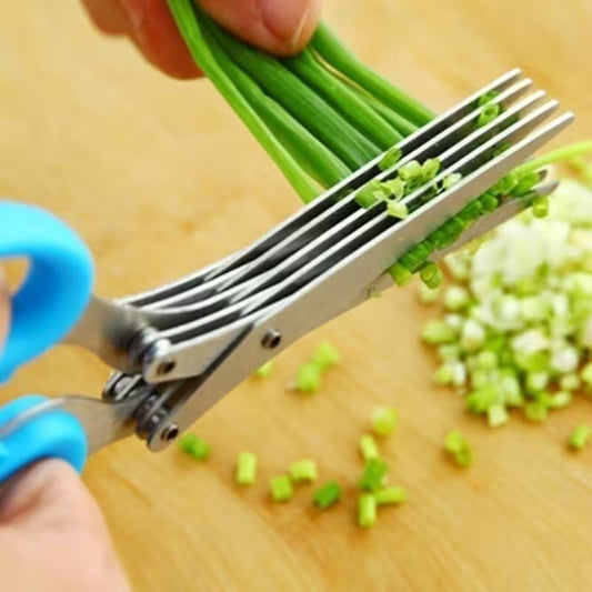 Scissors cutting green onions on a wooden surface