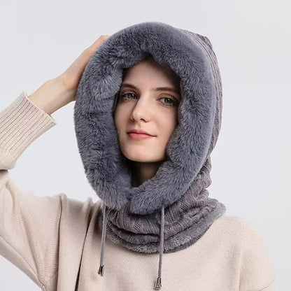 Person wearing a gray fluffy hooded scarf against a white background