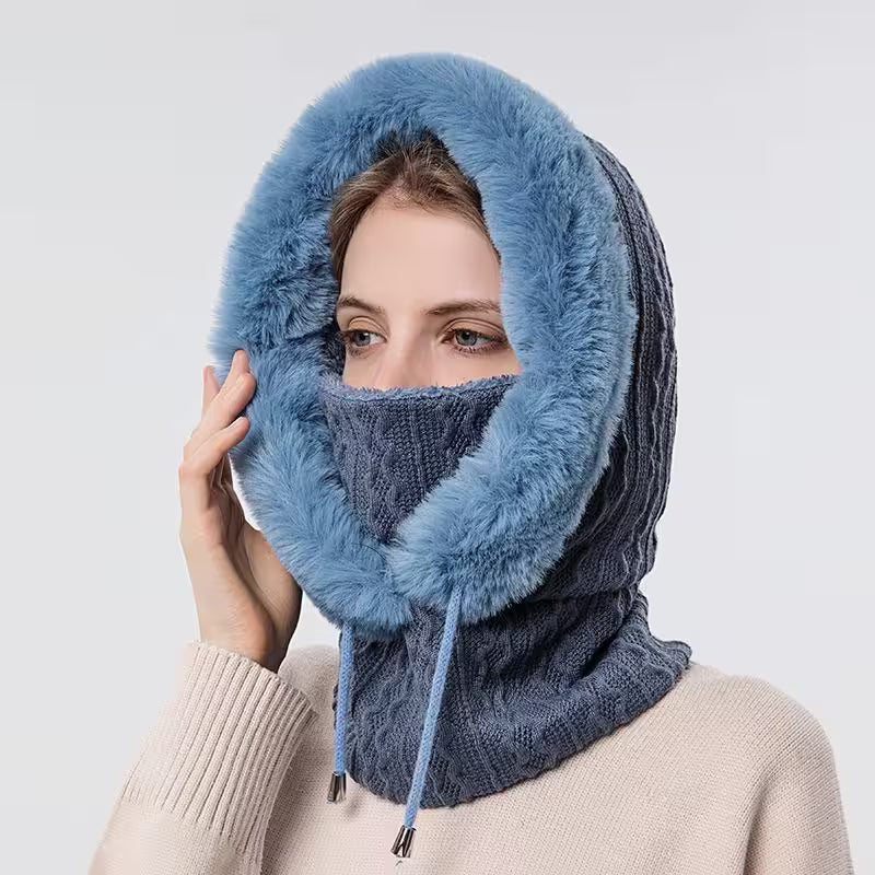 Person wearing a blue knitted hood and scarf on a white background