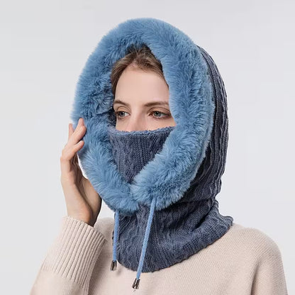 Person wearing a blue knitted hood and scarf on a white background