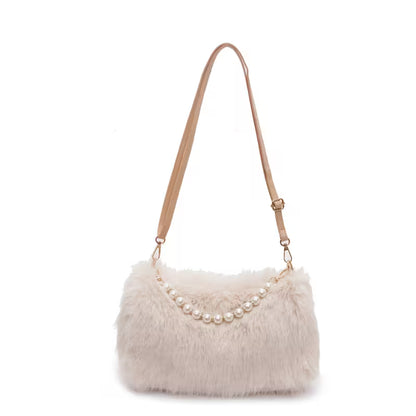 Beige fur handbag with pearl embellishments on a white background