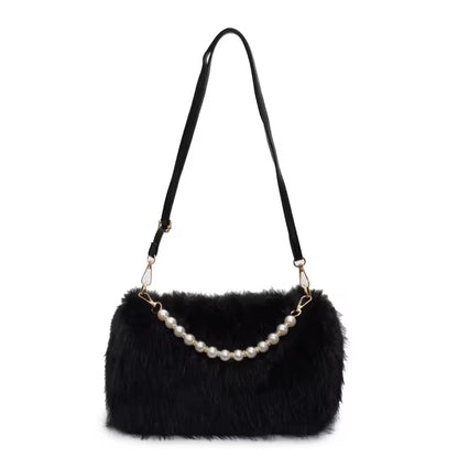 Black fur handbag with pearl handle on a white background