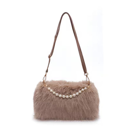 Brown fur handbag with pearl necklace detail on a white background