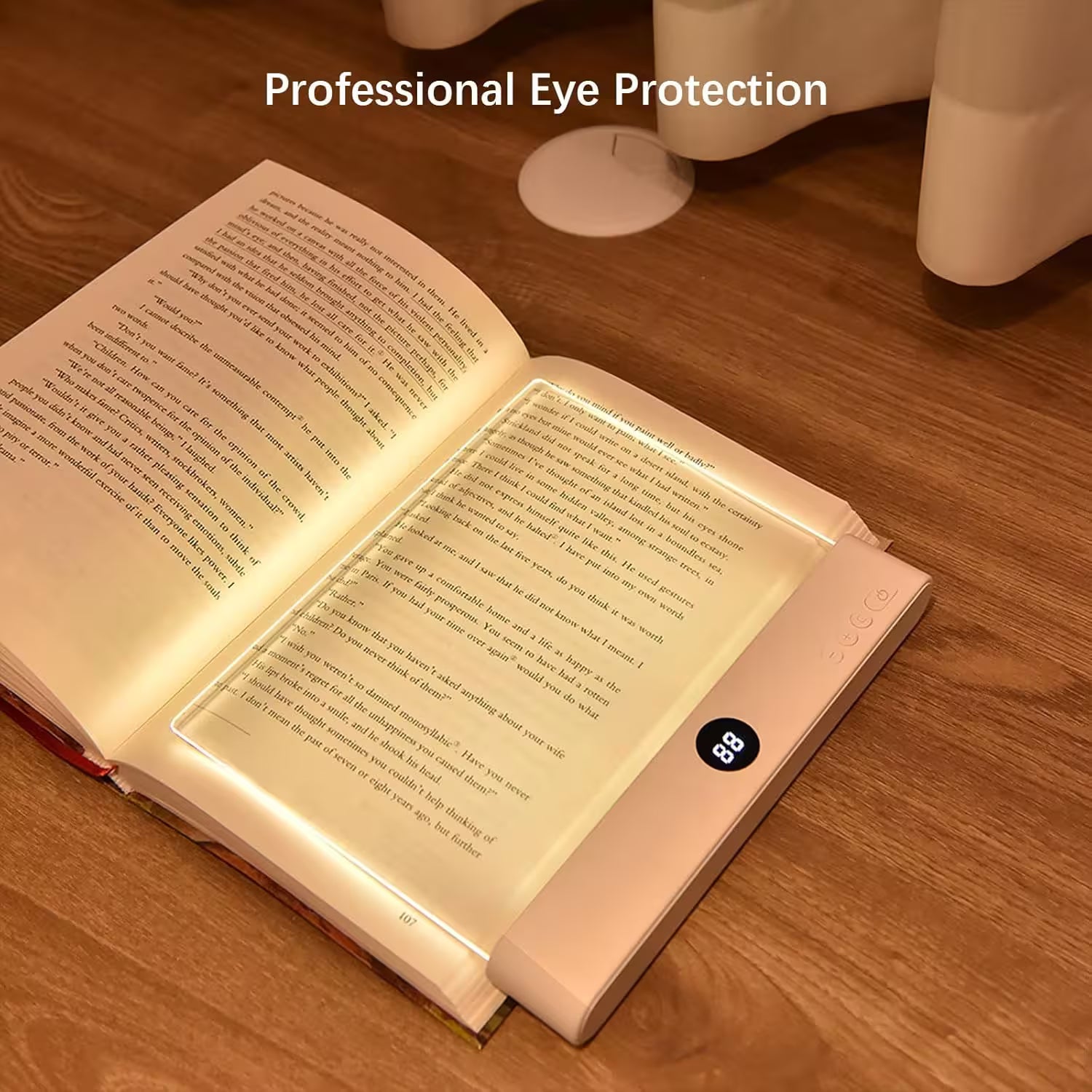 Open book with a light pad on a wooden surface, emphasizing eye protection.