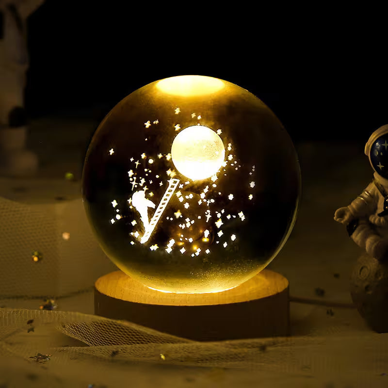 Glowing crystal ball with astronaut and moon design on a wooden base, surrounded by space-themed decor.