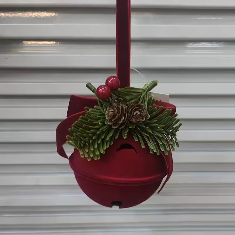 Red bird feeder with greenery and berries against a metallic background