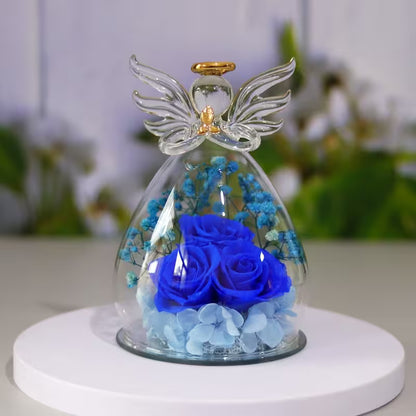 Glass angel figurine with blue roses and flowers on a white base