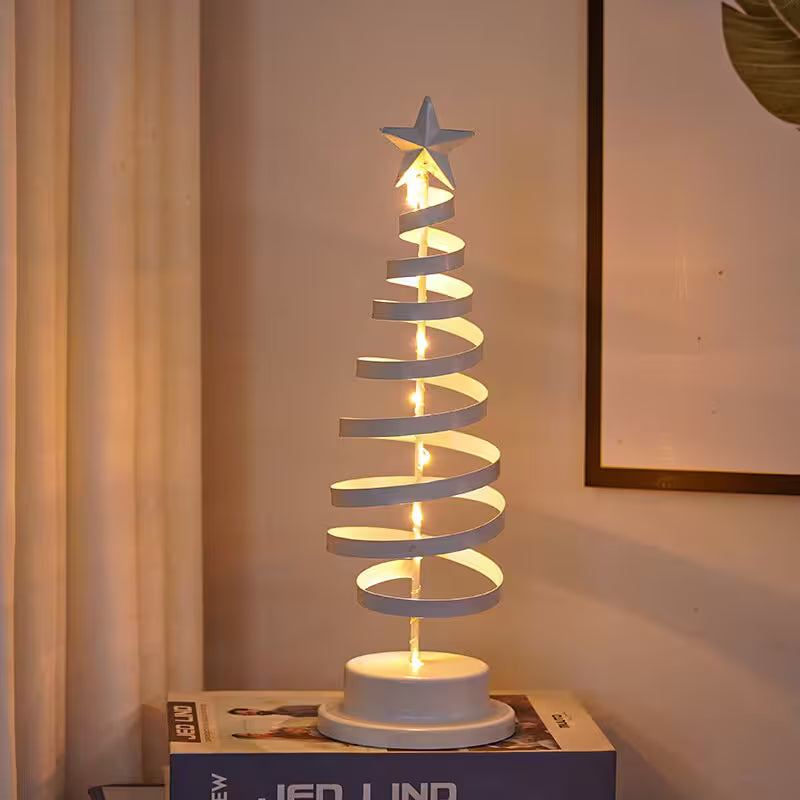 Decorative spiral lamp with a star on top, placed on a surface with a neutral background.
