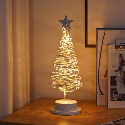 Decorative LED Christmas tree lamp on a wooden surface with a star on top.