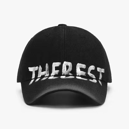 Black cap with 'THE REST' printed in white on a light gray background