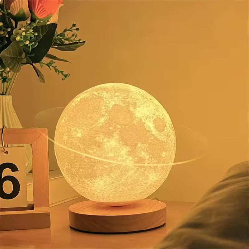 Moon lamp on a wooden base with a decorative setting including flowers and a calendar.