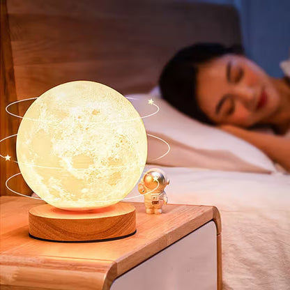 Person sleeping with a moon-shaped night light on a bedside table