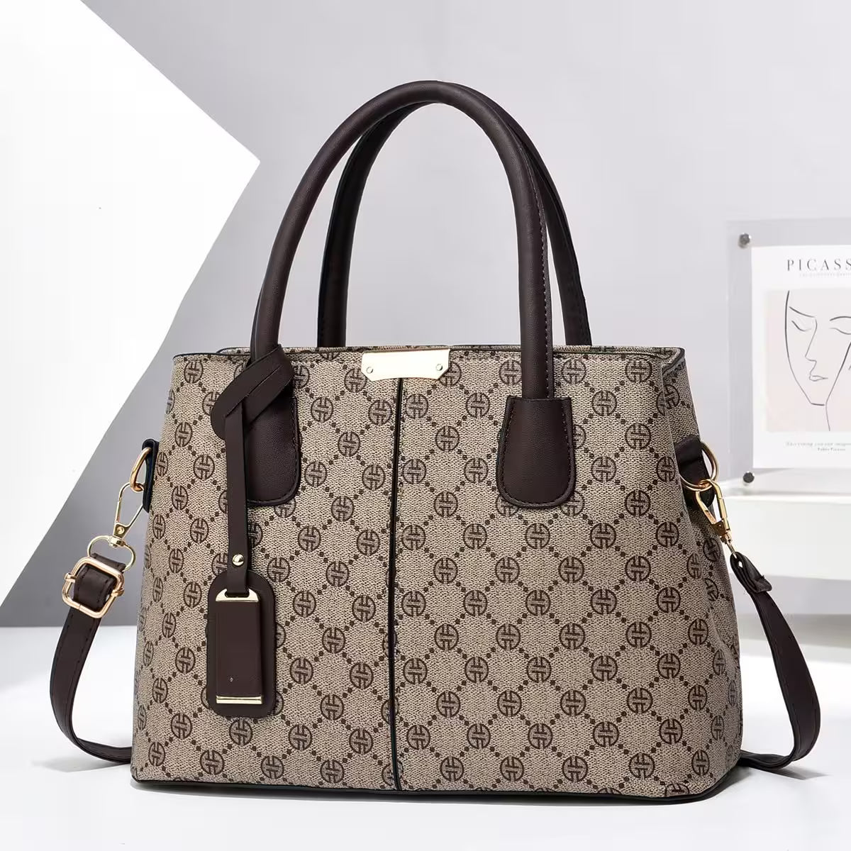 Patterned handbag with brown handles and strap on a white background