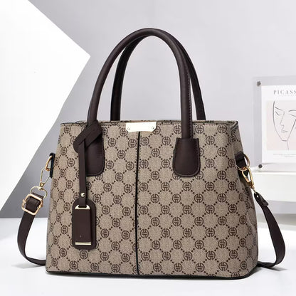 Patterned handbag with brown handles and strap on a white background