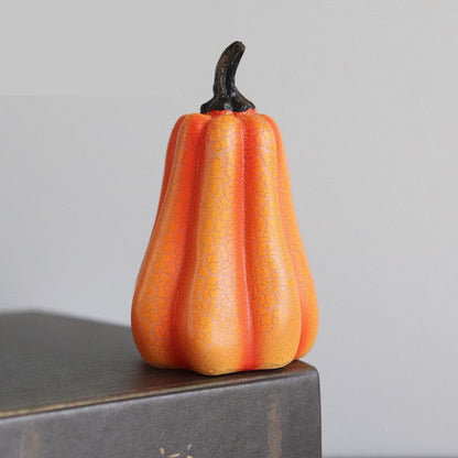 Decorative orange gourd on a gray surface with a neutral background