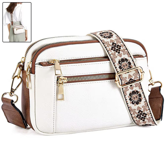 White handbag with floral strap and gold zippers on a white background