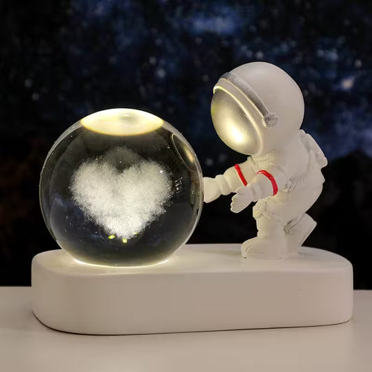 Astronaut figurine interacting with a glass ball against a dark space-themed background