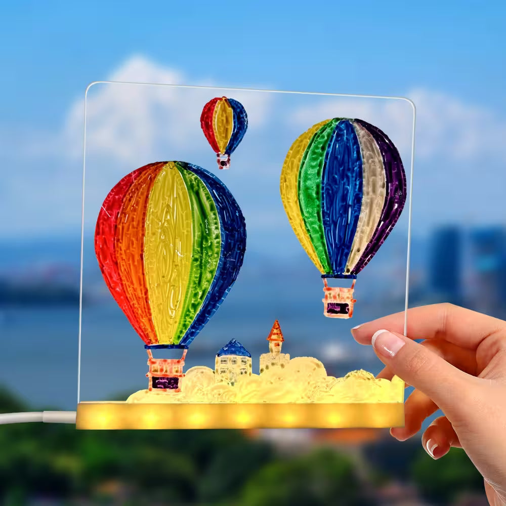 Colorful hot air balloon lamp with a hand holding it against a blurred outdoor background